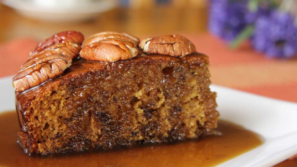 Dates Pudding with walnut as a top ins placed in a white plate