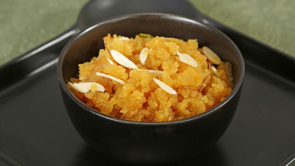 Moong dal Halwa in a black bowl and place in a black plate