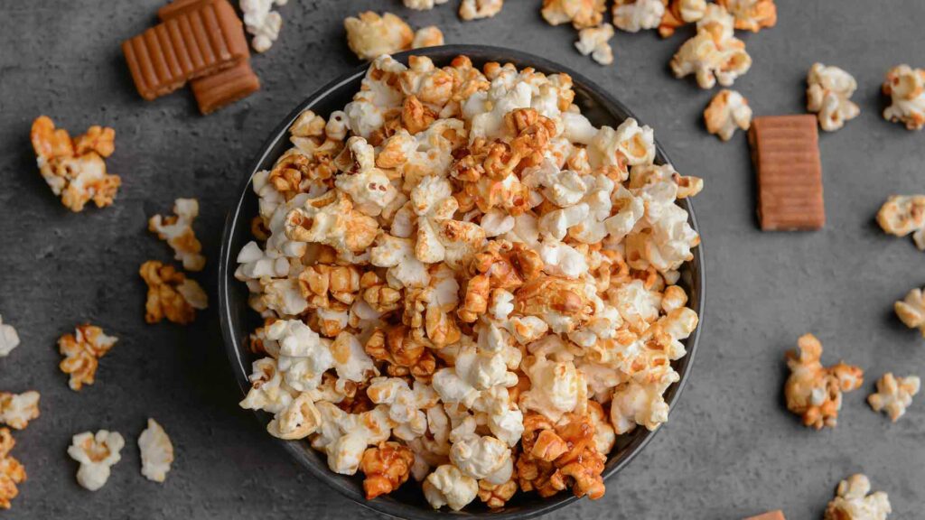 Popcorn in a grey plastic bowl and placed in a grey background