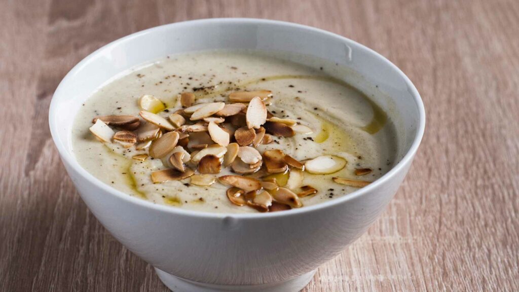 Almond Soup in a white bowl and placed in a wooden table